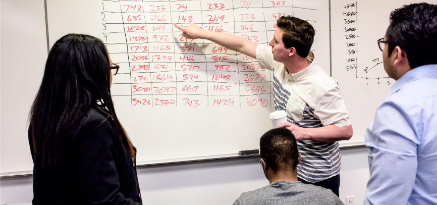 Students working on whiteboard in GMAT workshop