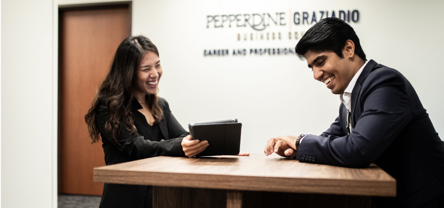 Two students talking together at table