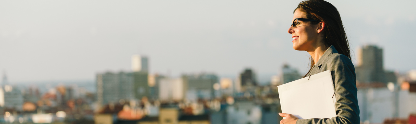 Business woman outside looking over city skyline
