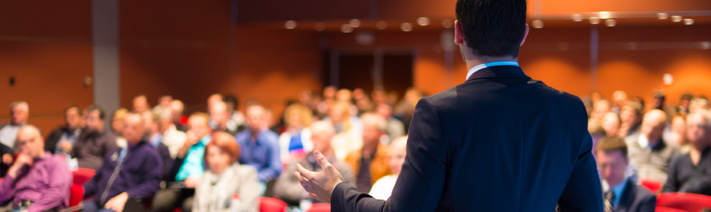 Business man lecturing at large seminar event