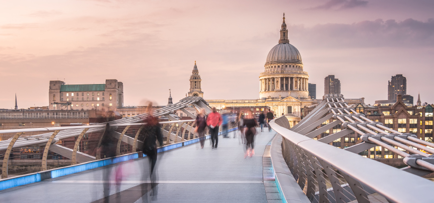People walking across the millenium bridge near St. Paul's Cathedral in London, United Kingdom